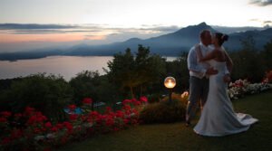 Luxury destination wedding ceremony overlooking Santorini cliffs at sunset with bride and groom